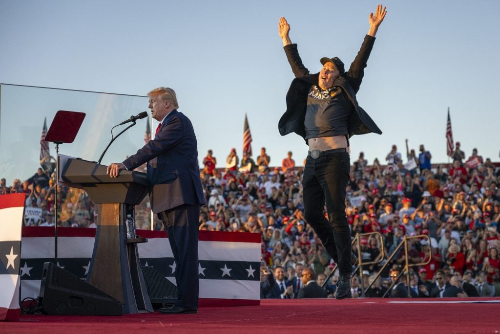 Tesla CEO Elon Musk jumps on stage as he joins former US President and Republican presidential candidate Donald Trump during a campaign rally at site of his first assassination attempt in Butler, Pennsylvania on October 5, 2024.