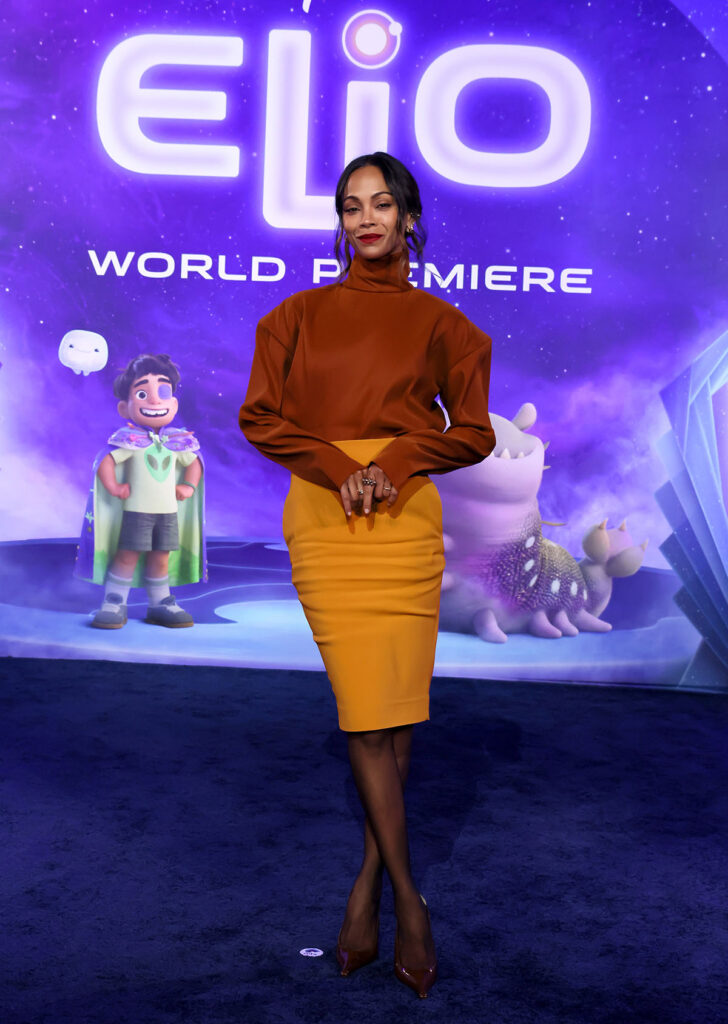 Zoe Saldaña attends the World Premiere of Disney and Pixar's "Elio" in Saint Laurent orange top and yellow skirt.