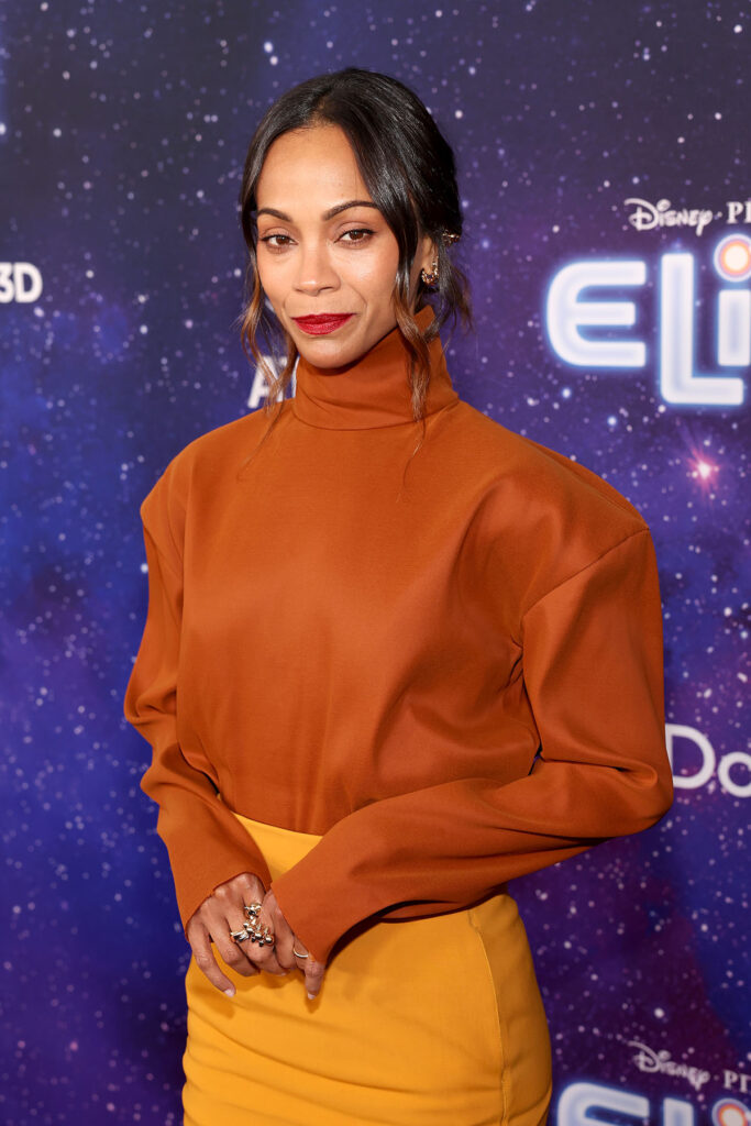 Zoe Saldaña attends the World Premiere of Disney and Pixar's "Elio" in Saint Laurent orange top and yellow skirt.