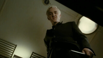 Tom Felton as Draco Malfoy glaring downward in Harry Potter and the Half-Blood Prince