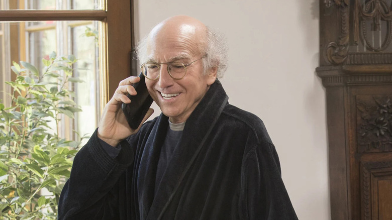 Larry David smiling while on the phone in Curb Your Enthusiasm